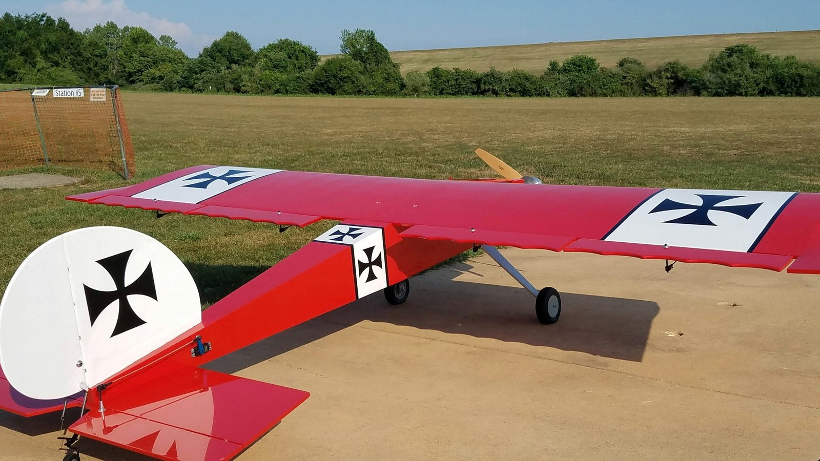 red and white plane on brown field during daytime